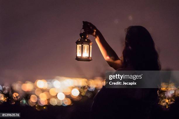 mujer que sostiene una linterna - jack o lantern fotografías e imágenes de stock