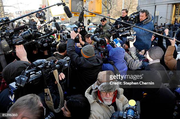 Huge crush of media surrounds a defrauded investor outside of a Manhattan Federal court after disgraced financier Bernard Madoff was sent by a judge...