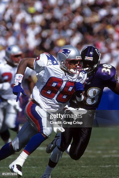 Terry Glenn of the New England Patriots runs on the field as Antonio Langham of the Baltimore Ravens shadows him during their game on October 6, 1996...