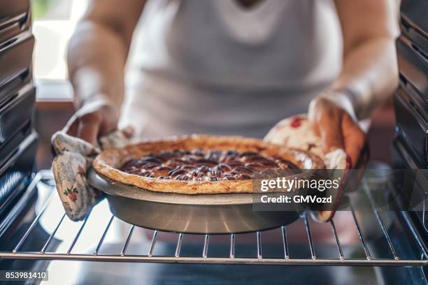 baking pecan pie in the oven for holidays - fazer doces imagens e fotografias de stock