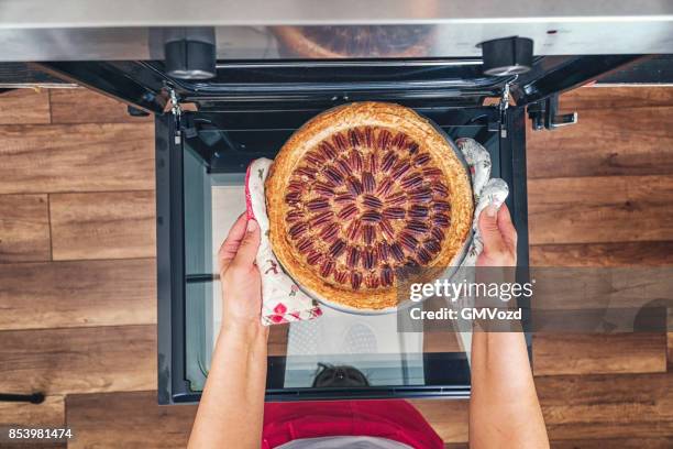 cuocere la torta di pecan nel forno per le vacanze - torta foto e immagini stock