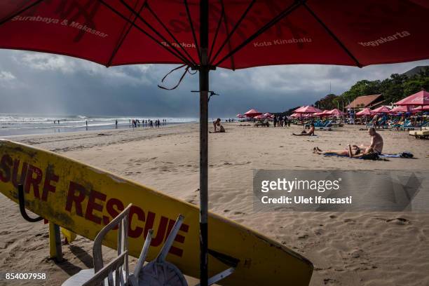 Tourists sunbathe at Kuta beach on September 26, 2017 in Kuta, Island of Bali, Indonesia. Indonesian authorities raised the alert level for the Mount...