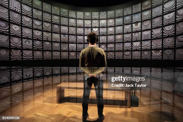 An employee poses in front of 'Fratelli d'Italia' by Matthias Schaller at the Victoria and Albert Museum during a photocall for their Opera: Passion,...