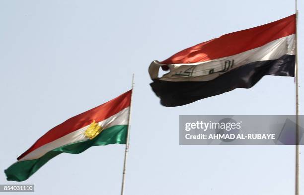 General view shows the Kurdish and Iraqi flags flying next to each other in Kirkuk on September 26 after a curfew on parts of the city was lifted...
