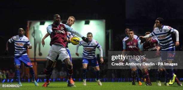 West Ham's Carlton Cole and QPR's Clint Hill compete for possession during the Barclays Premier League match at Upton Park, London.