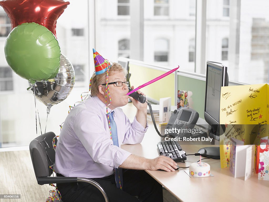 Businessman having birthday party at desk
