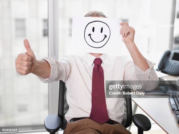 businessman holding picture of happy face - smiley face thumbs up stock pictures, royalty-free photos & images