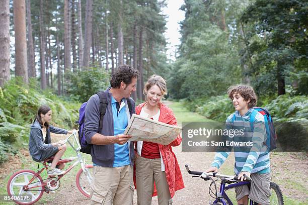 family using map in woods - family decisions stock pictures, royalty-free photos & images