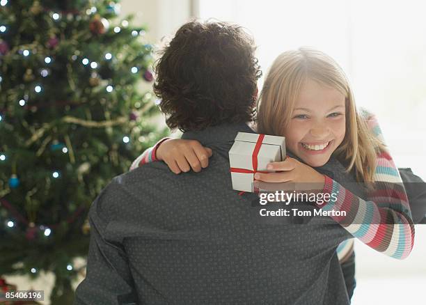 tochter umarmen vater holding christmas gift - child giving gift stock-fotos und bilder