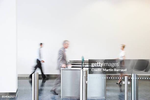 los empresarios caminando a través de torniquete - barrier fotografías e imágenes de stock