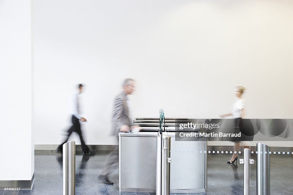 Businesspeople walking through turnstile