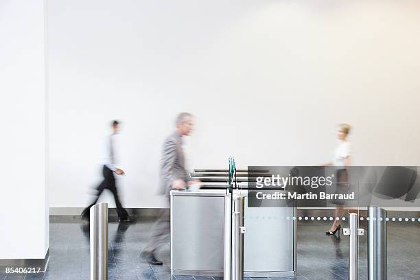 businesspeople walking through turnstile - entering stock pictures, royalty-free photos & images