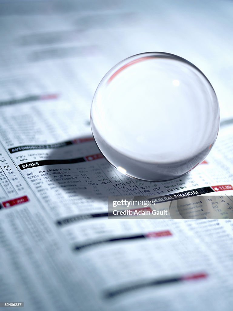 Close up of glass ball on newspaper