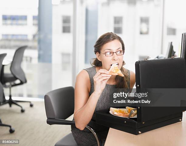 mujer de negocios comer pizza de maletín - over eating fotografías e imágenes de stock