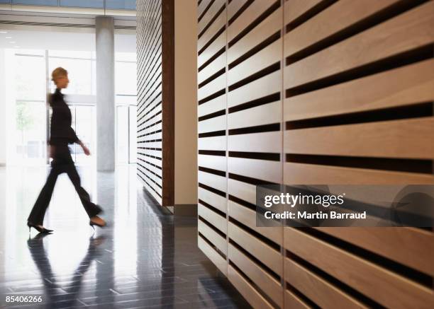 businesswoman walking in corridor - wood material architectural wall stock pictures, royalty-free photos & images