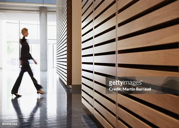 mulher de negócios andar no corredor - blurred office imagens e fotografias de stock