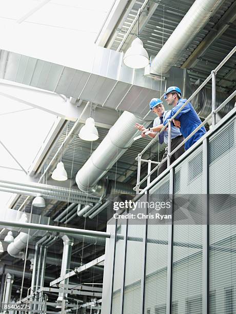 businessmen in hard-hats talking - looking over balcony stock pictures, royalty-free photos & images