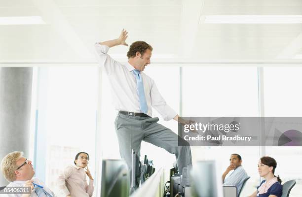 businessman dancing on desk in cubicle - arrogant smile stock pictures, royalty-free photos & images
