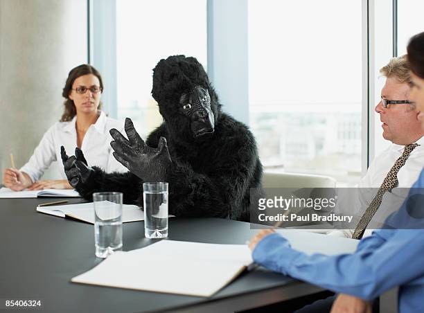 gorilla and businesspeople having meeting in conference room - day 4 stockfoto's en -beelden