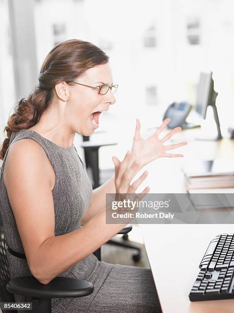 angry businesswoman shouting at computer - robert madden stock pictures, royalty-free photos & images