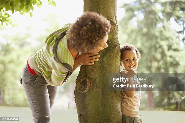 mother playing hide and seek with son - vinden stockfoto's en -beelden
