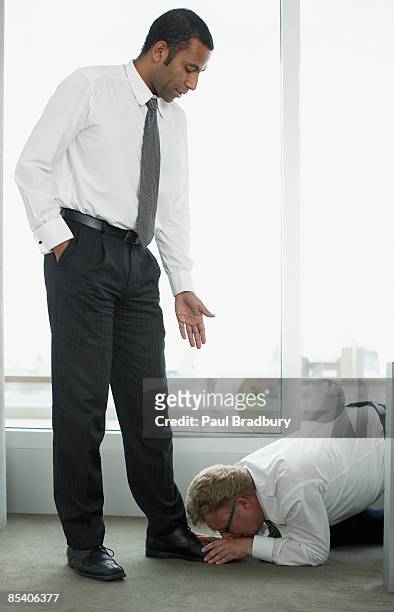 businessman kissing boss feet - feet kiss stockfoto's en -beelden
