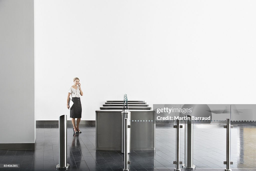 Mulher de negócios com telefone celular perto de Torniquete