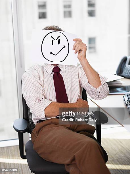 businessman holding picture of angry face - robert madden stock pictures, royalty-free photos & images