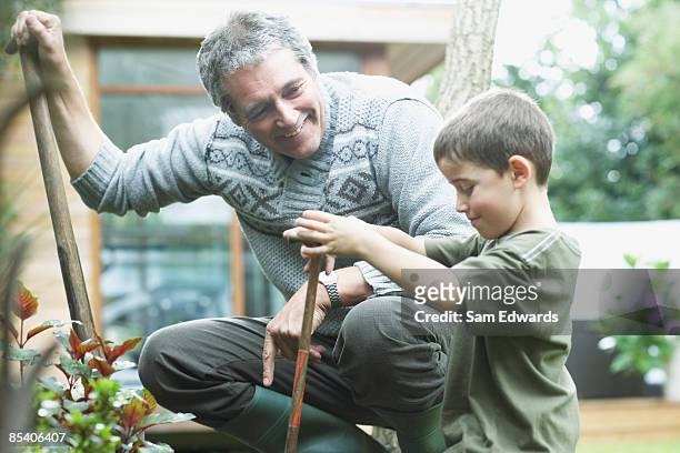 grandfather and grandson gardening - family in garden stock pictures, royalty-free photos & images