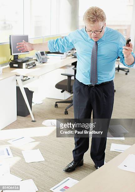businessman looking at papers on floor - 40's rumpled business man stockfoto's en -beelden