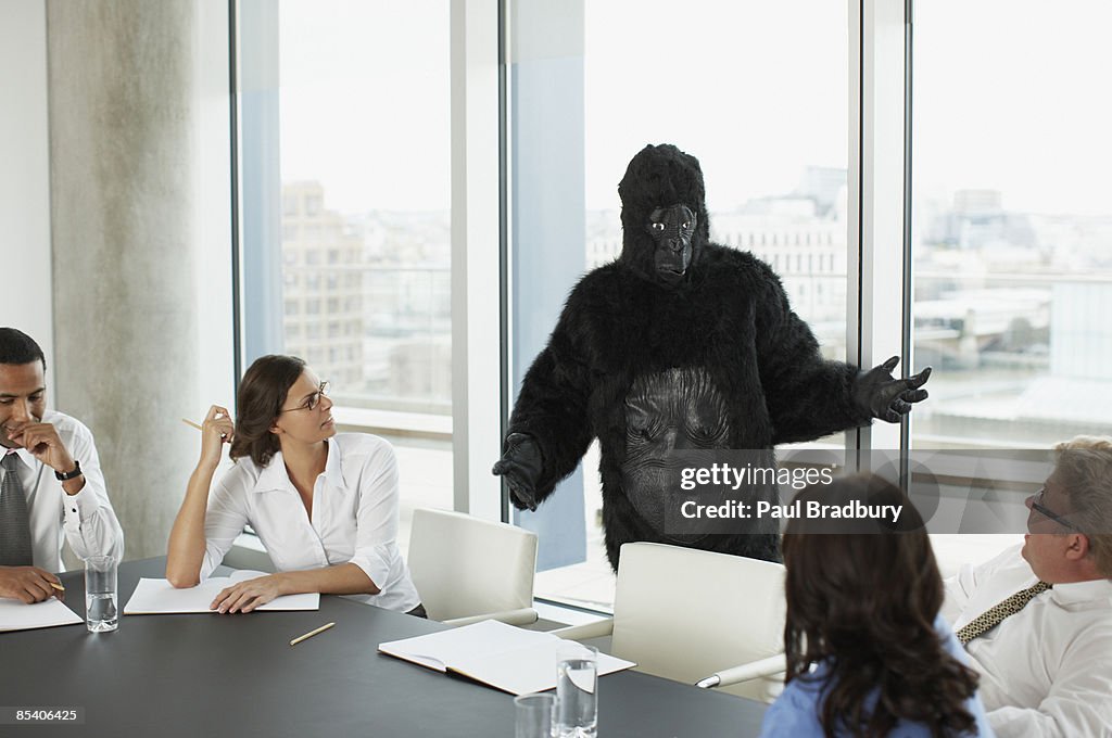 Gorilla and businesspeople having meeting in conference room