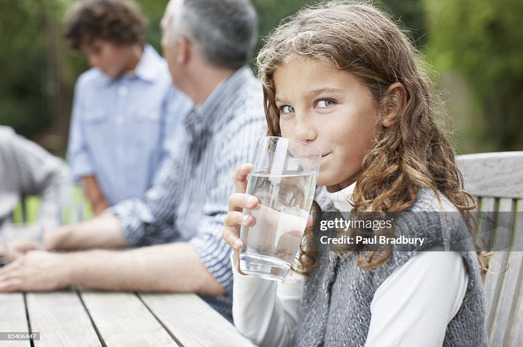 Girl drinking water at picnic table