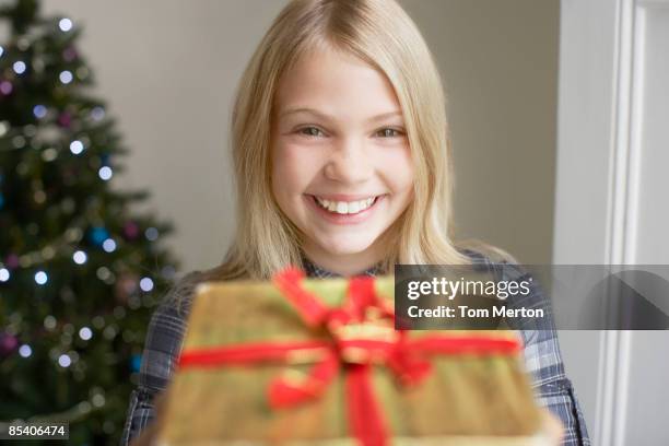 mädchen holding out weihnachten geschenk - child giving gift stock-fotos und bilder