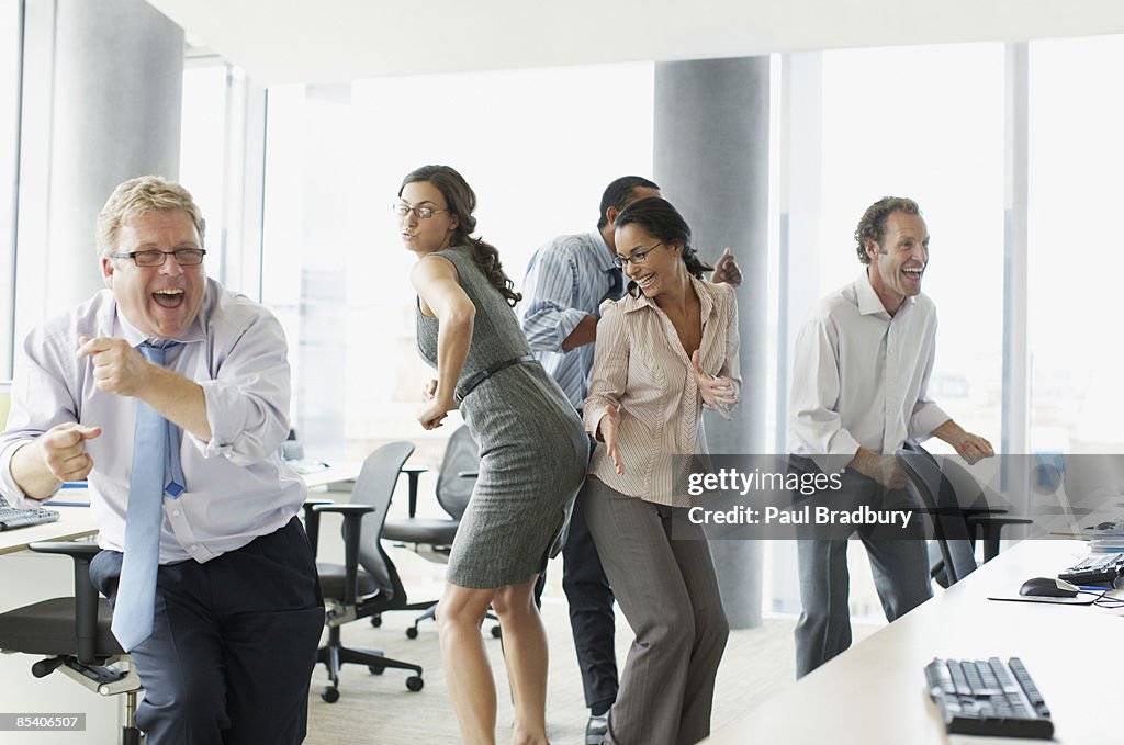 Businesspeople dancing in office