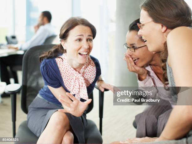 geschäftsfrauen gossiping im büro - flüstern stock-fotos und bilder