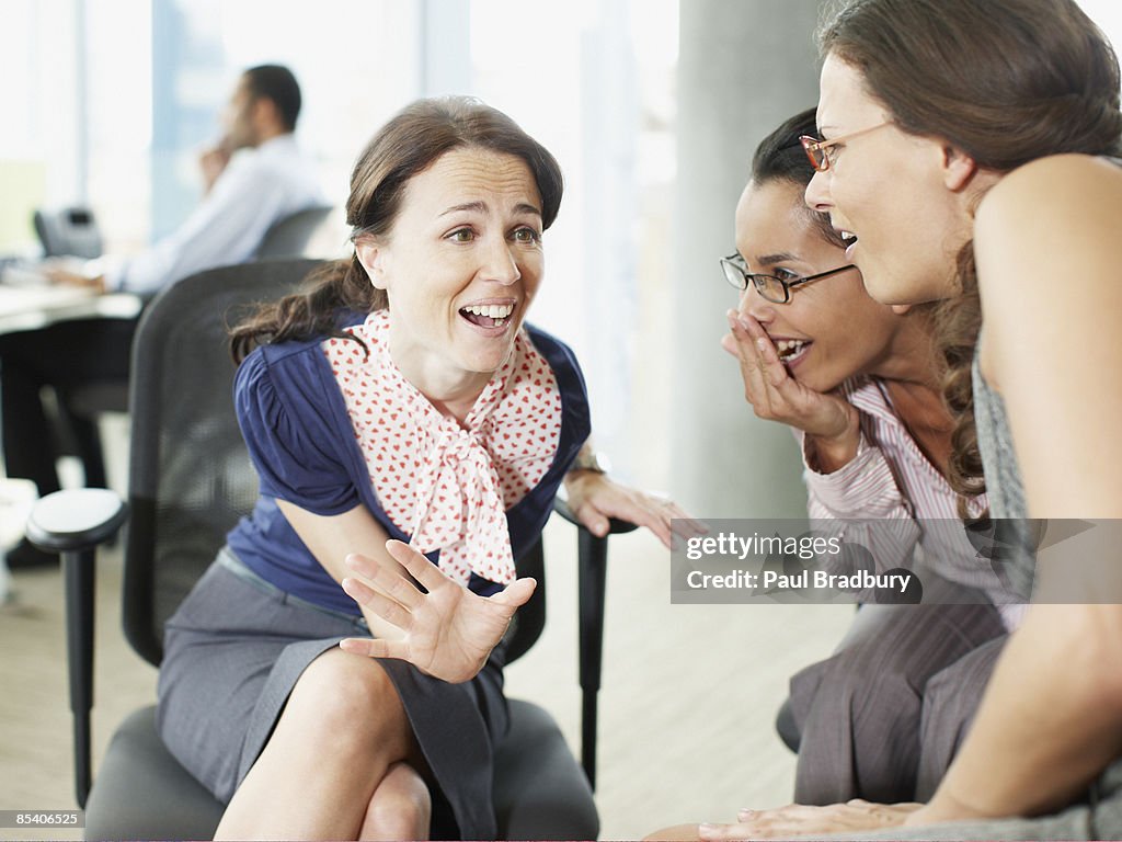 Businesswomen gossiping in office