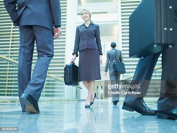 businesspeople walking in corridor - lower employee engagement stock pictures, royalty-free photos & images