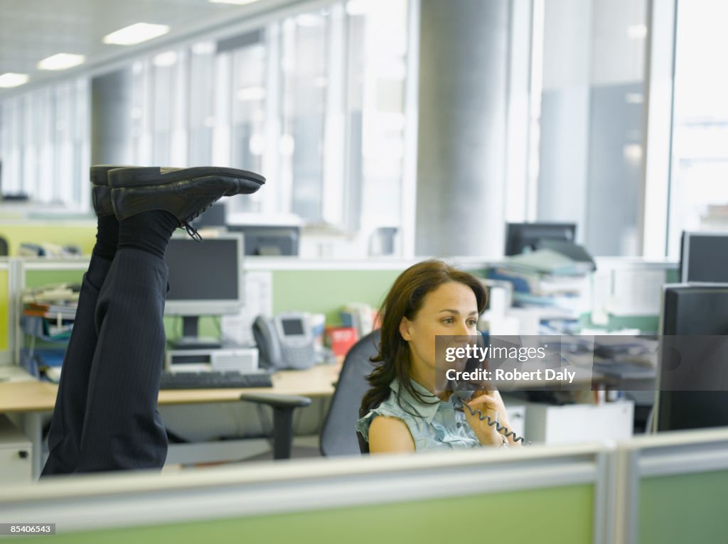 Businessman doing headstand in office