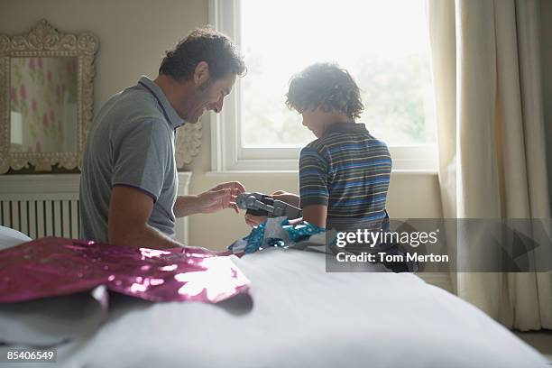 father giving son christmas gift - open day 2 stock pictures, royalty-free photos & images