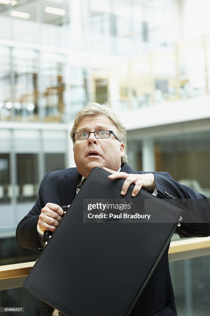 Afraid businessman holding briefcase