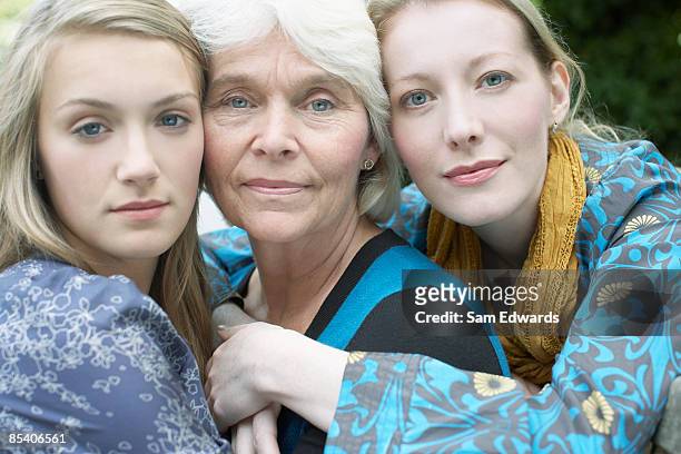 grandmother, mother and daughter hugging - family serious stock pictures, royalty-free photos & images
