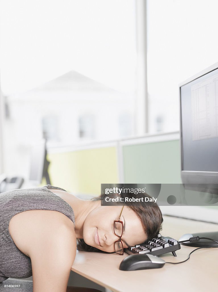 Businesswoman sleeping on computer keyboard