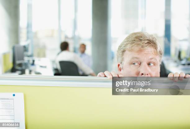 businessman peering over cubicle wall - build presents the cast of liar stockfoto's en -beelden