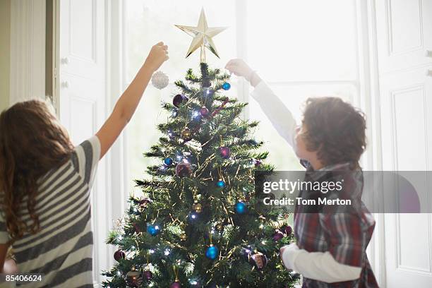 figli decorare l'albero di natale - decorare l'albero di natale foto e immagini stock