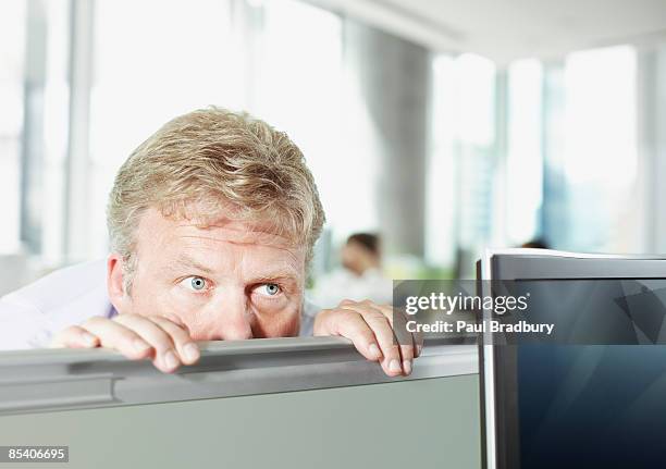 businessman peering over cubicle wall - eavesdropping stock pictures, royalty-free photos & images