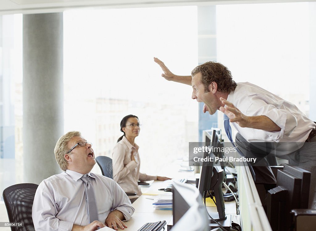 Businessman scaring co-worker in office