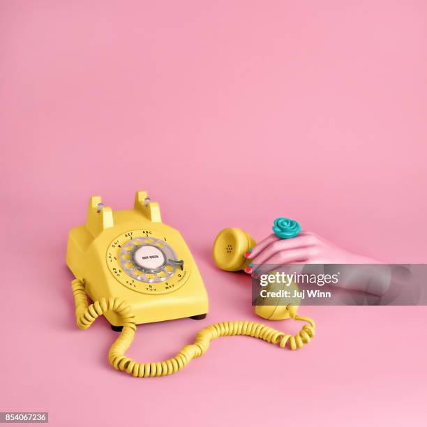 mannequin hand holding yellow rotary phone - fake hand stock pictures, royalty-free photos & images