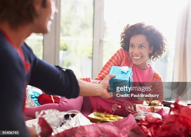 hombre dando mujer de navidad regalos - dar fotografías e imágenes de stock
