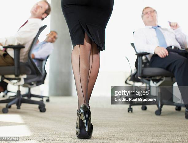 uomini d'affari guardando sexy co-worker - seduzione foto e immagini stock