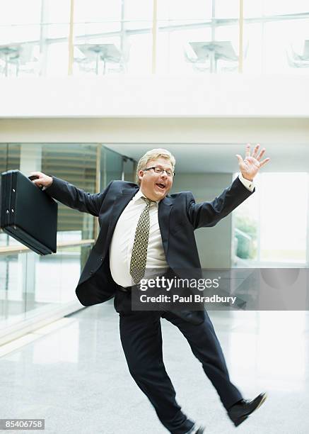 businessman dancing in office lobby - business people cheering in office stockfoto's en -beelden